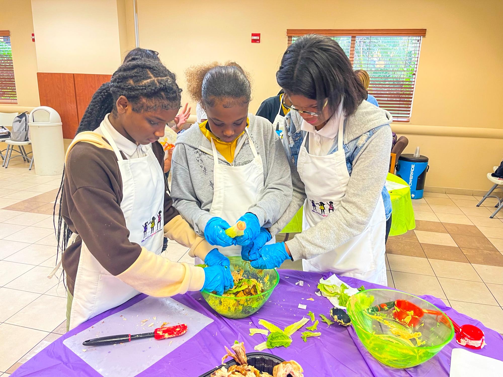 Honey Bugs participating in a hands-on cooking demonstration facilitated by Black Girls Cook, who provided all the ingredients, cookware and recipes for our girls.