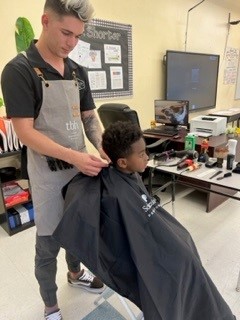 a young boy from OYC receives a haircut courtesy of Bank of America
