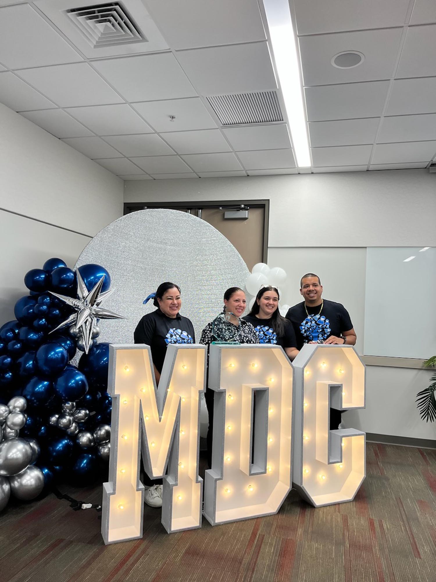 OYC staff poses behind an MDC logo
